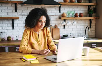 Person working on a laptop in a home kitchen