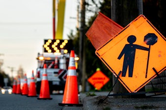 Road work signage and pylons on a roadway.