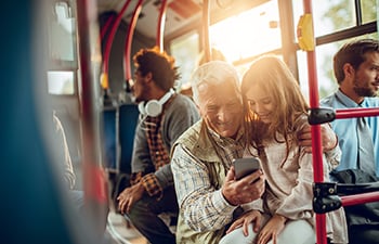 Grandfather and granddaughter riding in a bus.
